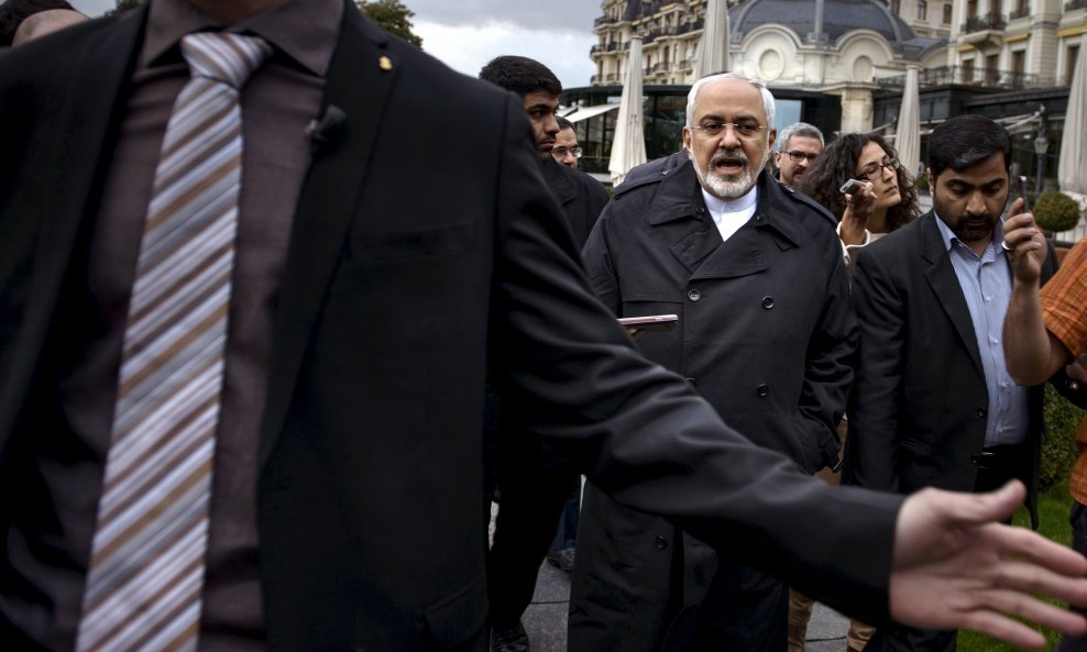 Iranian Foreign Minister Javad Zarif talks to members of the media while walking through a courtyard at the Beau Rivage Palace Hotel during an extended round of talks in Lausanne April 1, 2015. Zarif said on Wednesday that the nuclear talks with the succe
