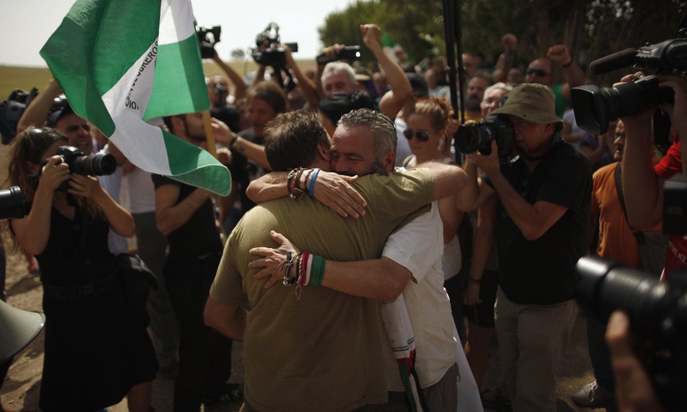 Juan Manuel Sanchez Gordillo (R) embraces to a member of SAT (Andalusian Union of Workers), Andres Amaro,