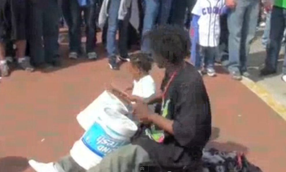 Slatki trogodišnjak s ocem svira bubnjeve na cesti