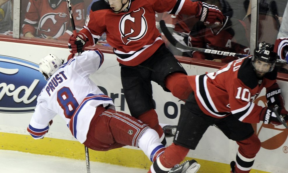 New Jersey Devils' Anton Volchenkov (C) checks New York Rangers' Brandon Prust (L) with teammate New Jersey Devils' Peter Harrold d