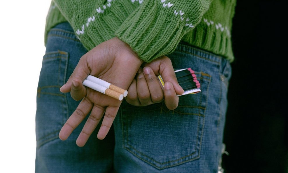 djevojka skriva cigarete iza leđa