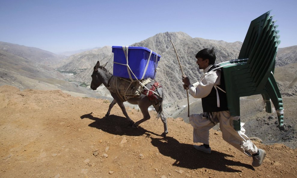Čovjek uz pomoć magarac prenosi priručna pomagala na biračka mjesta u Sighawaru u afganistanskoj planinskoj regiji Panjshir. Predsjednički izbori u Afganistanu održat će se 20. kolovoza.