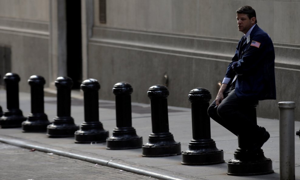 A trader takes a break outside the New York Stock Exchange (NYSE) on Wall Street in New York City, U.S., July 11, 2016. REUTERS/Brendan McDermid