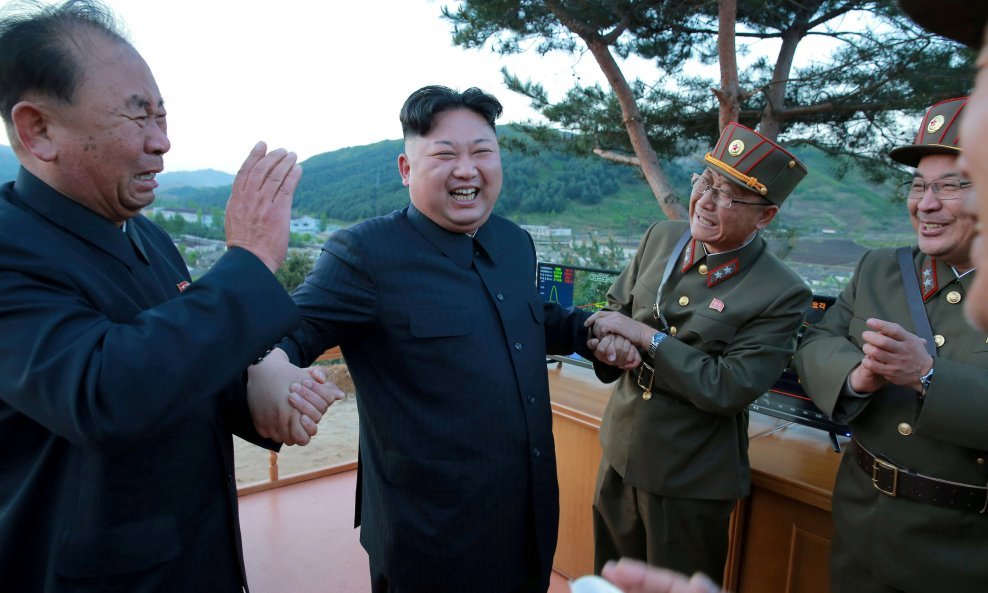 Ri Pyong Chol (lijevo) drži za ruku Kim Jong Una nakon uspješnog testiranja