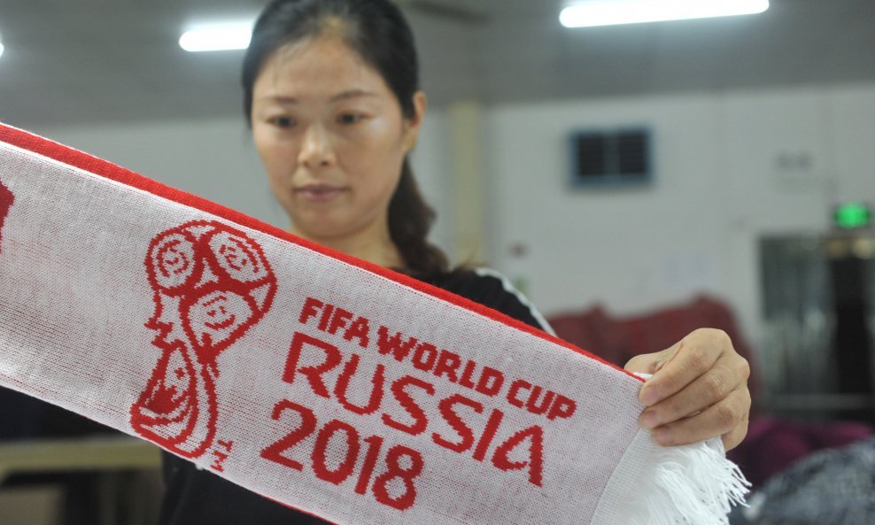 Radnica u tekstilnoj tvornici u Hangzhou izrađuje navijačke šalove za SP u nogometu u Rusiji