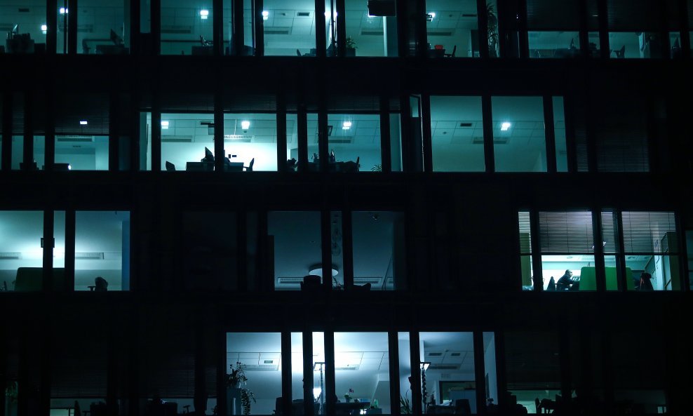Svjetla u uredima zaposlenika koji rade prekovremeno - ilustracija