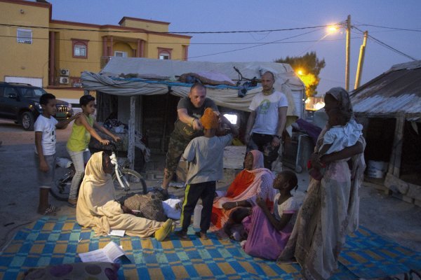 Žene koje smo sreli na ulici ispred našeg svratišta u Nouakchottu i dopratili ih do njihovog malog slama. Damir Filipović jednom dječaku stavlja na glavu kapu koju je izradila Spomenka Silvia Lazar iz Varaždina