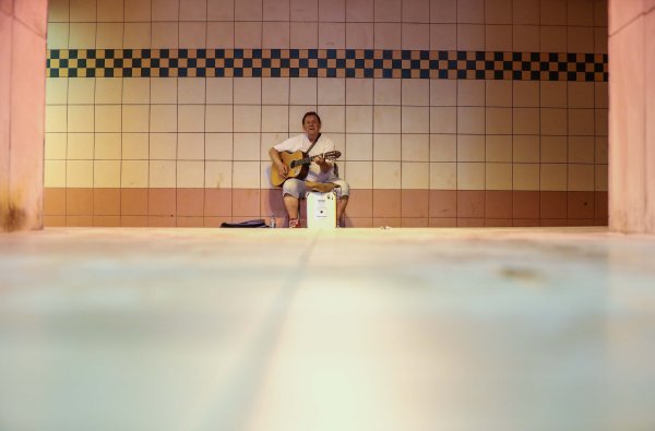 Ulični gitarist zabavlja rijetke prolaznike u pothodniku