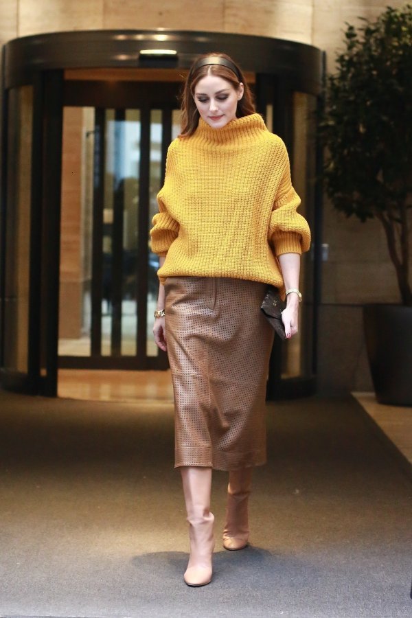 Kožna suknja pencil kroja u kombinaciji s visokim čizmama i predimenzioniranim puloverom