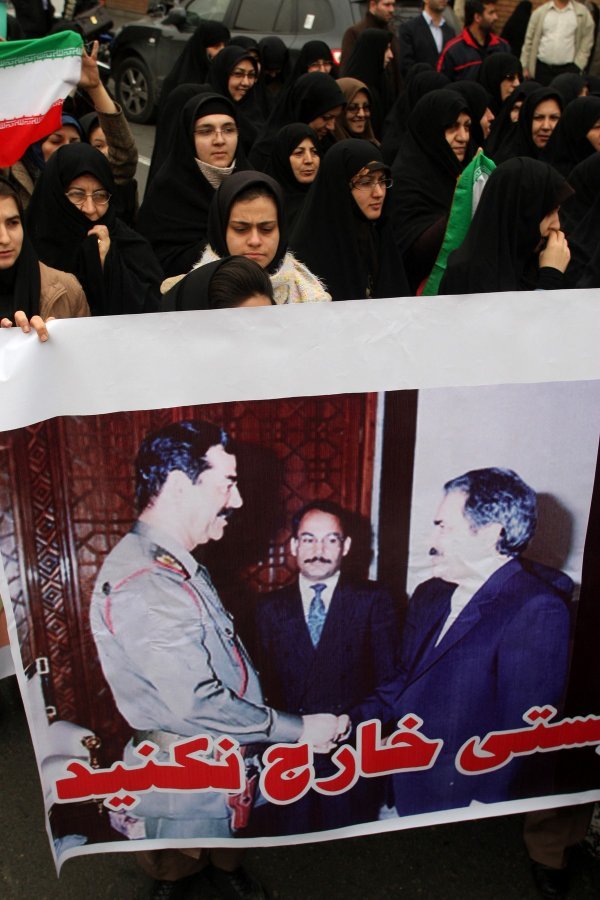 Iranski prosvjednici s fotografijom Huseina i čelnika MEK-a Rajavija