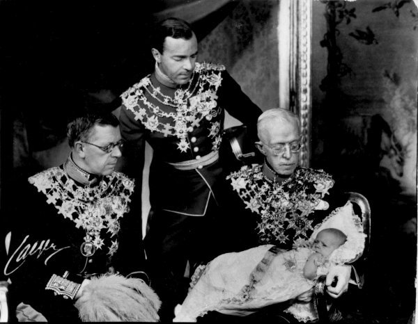 Krštenje princa Carla Gustafa kojeg drži pradjed, kralj Gustaf V., pored njega sjedi Gustaf VI i iznad je njegov otac Gustaf Adolf