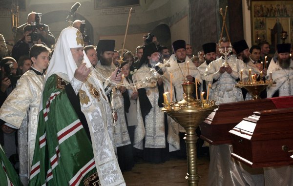 Ruski pravoslavni patrijarh Aleksej II ispred ljesova ruskog carskog generala Antona Denikina i filozofa Ivana Iljina tijekom pogrebne ceremonije u  Moskvi 2005.