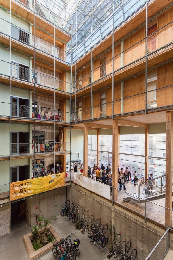 Centralni prostor s pogledom na zajedničku prostoriju zadrugara i parking bicikala, Stambena zadruga La Borda, Barcelona. Fotografija: Institut Municipal de l'Habitatge i Rehabilitació de Barcelona