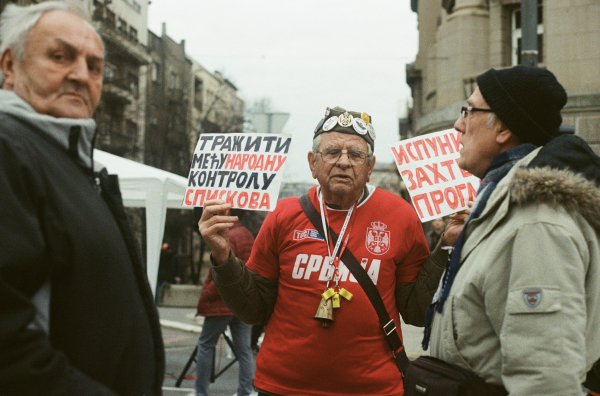 Veroljub Sarić bio je jedan od starijih prosvjednika na studentskoj blokadi. Na transparentima piše: Tražimo međunarodnu kontrolu izbora / Ispunite zahtjeve ProGlasa