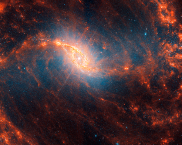 Spiralna galaksija NGC 1365 s ružičastim difrakcijskim šiljcima koji bi mogli ukazivati na aktivnu supermasivnu crnu rupu u srcu ove galaksije