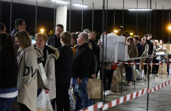 Red ispred Državnog izbornog povjerenstva, ljudi stoje s kutijama biračkih listića