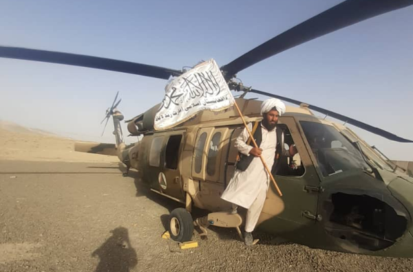 Pripadnik talibana pokraj ostavljenog američkog helikoptera Black Hawk