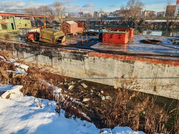 Zapušteni brod uz kojeg se zadržava smeće u rijeci