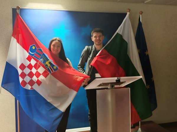 Bugarska novinarka Elya Izetova i novinar Tportala Ivor Kruljac načas su zamijenili zastave za komemorativnu fotografiju u novinarskoj sobi u Vijeću EU 