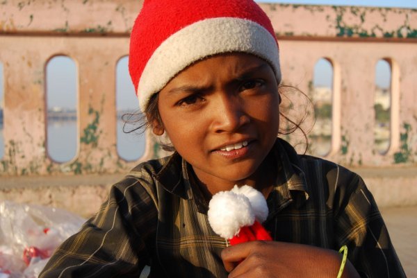 Djevojčica u Indiji džeparac zarađuje prodajući kape djeda božićnjaka